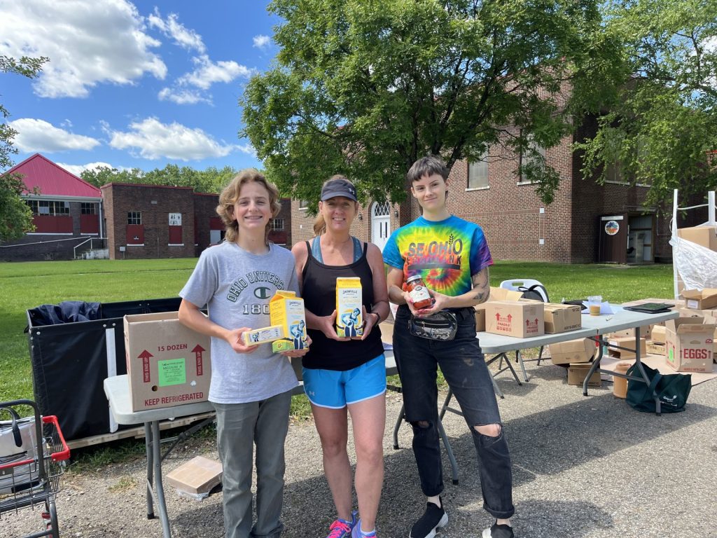 Photo of staff and volunteers holding food at a mini mobile