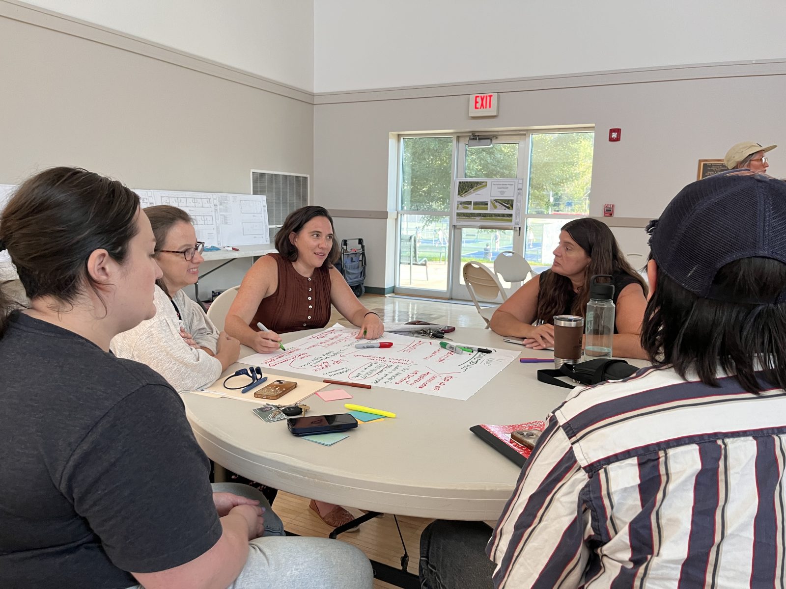 people sit around a table at the community center to discuss the Sunset Shelter Project