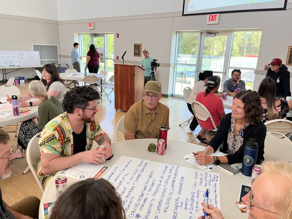 people sit around a table at the community center to discuss the Sunset Shelter Project