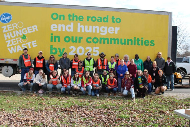 photo of volunteers posing in front of the SE Ohio Foodbank semi truck that reads "On the road to end hunger in our communities"
