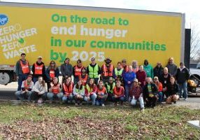 photo of volunteers posing in front of the SE Ohio Foodbank semi truck that reads "On the road to end hunger in our communities"